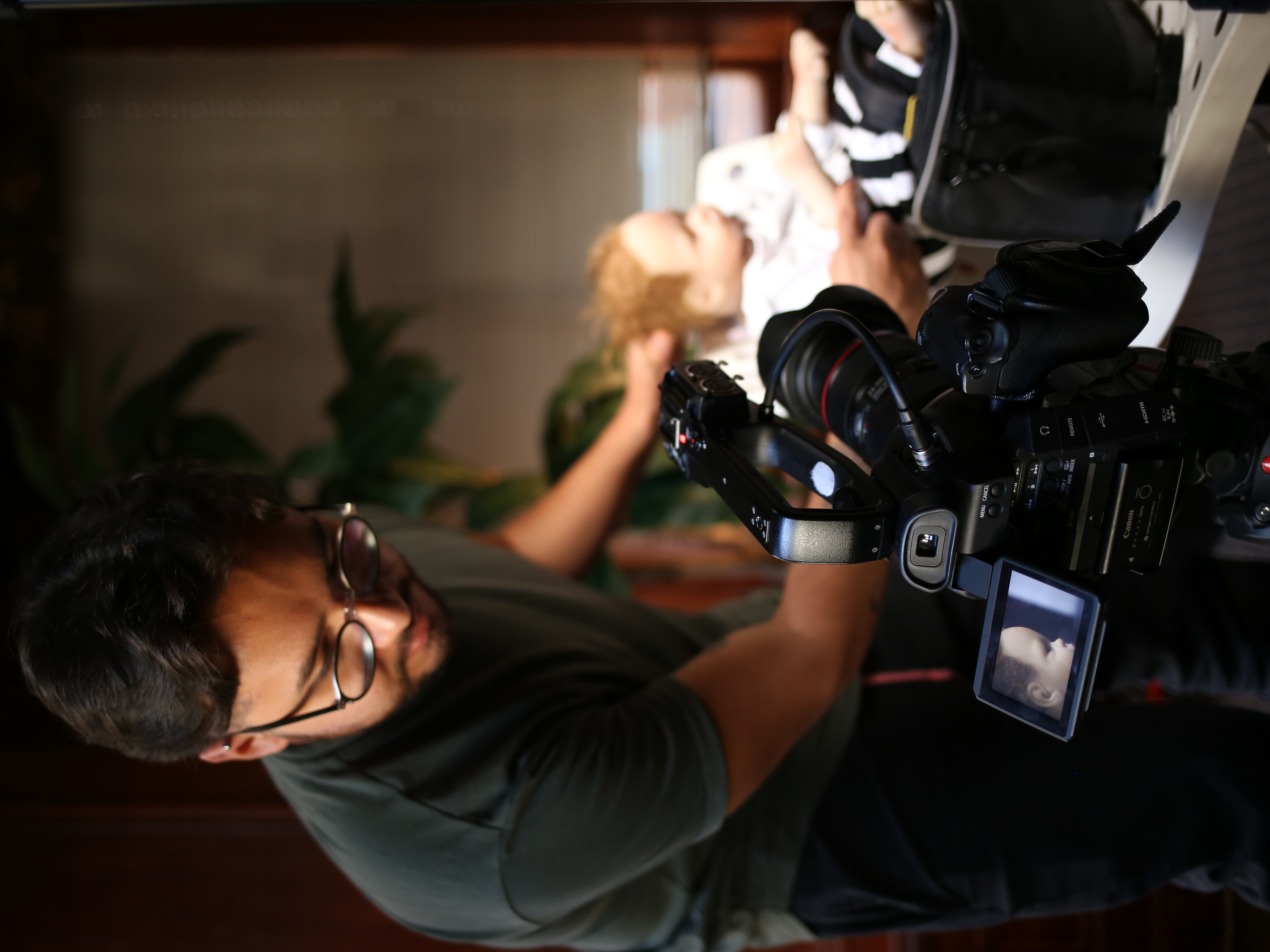 Camera operator framing a shot on a cinema rig during an interior shoot